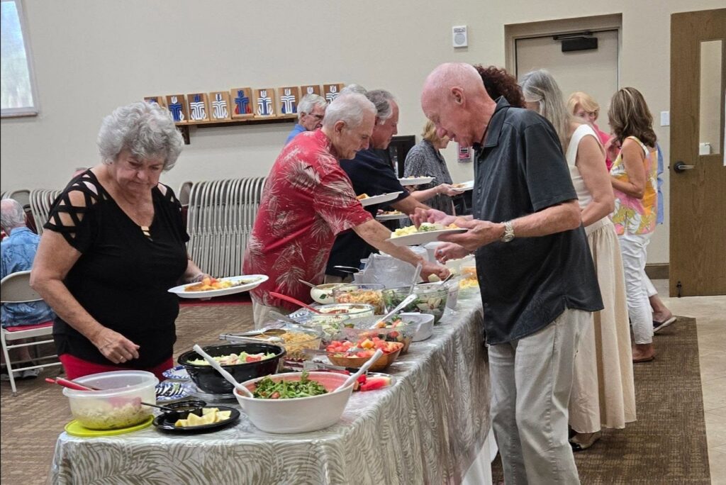 Guests serve themselves at an indoor buffet luncheon.
