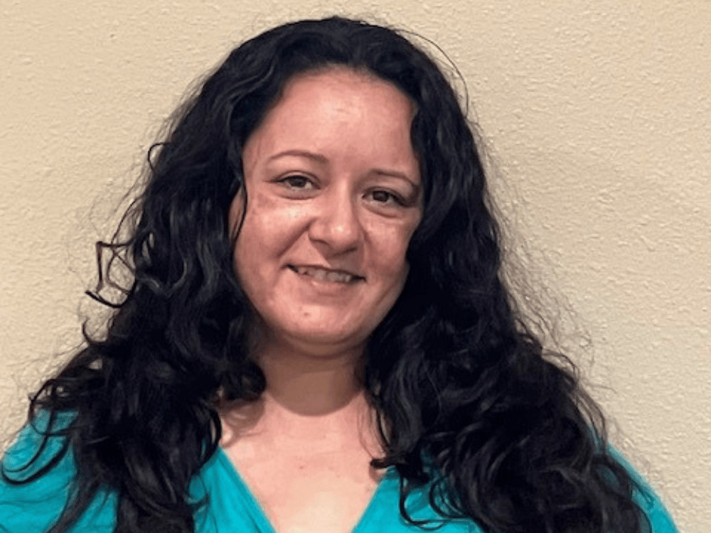 Smiling woman with long dark curly hair