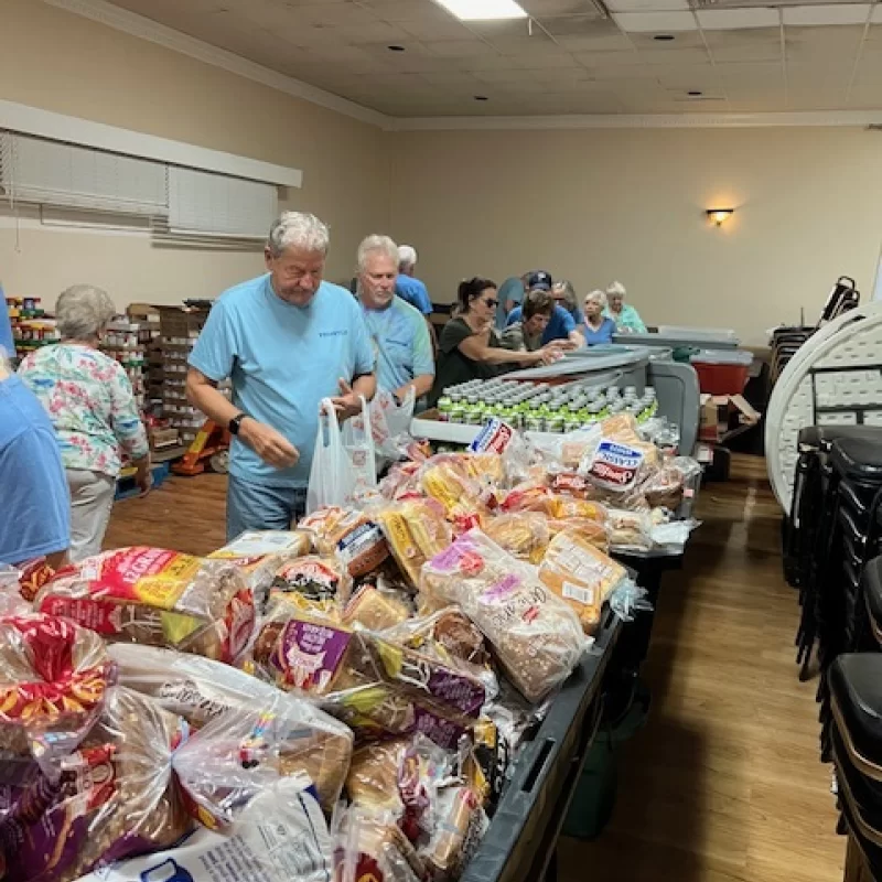 Volunteers bag bread and groceries at a food pantry