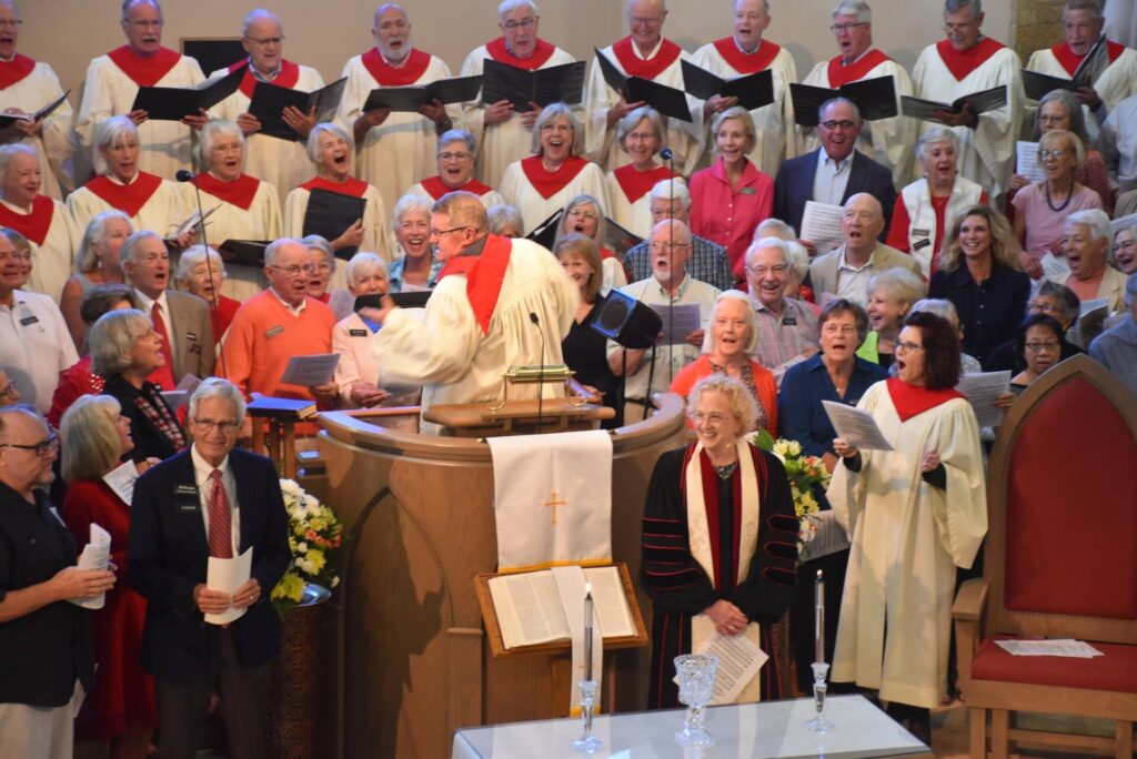 Church choir sings during worship service with clergy