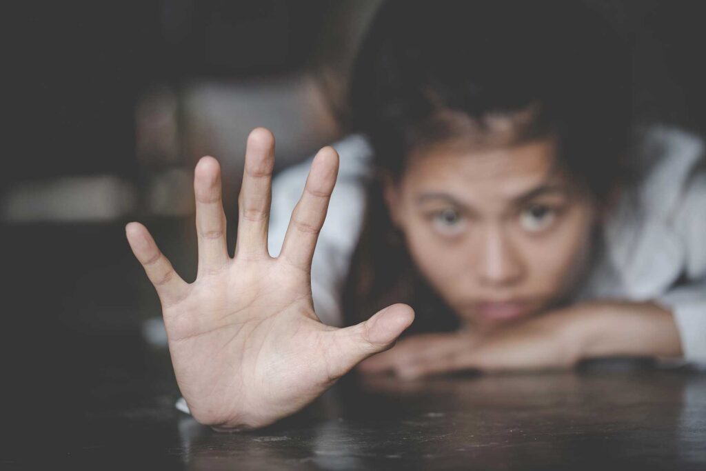 Woman reaches hand toward camera from table
